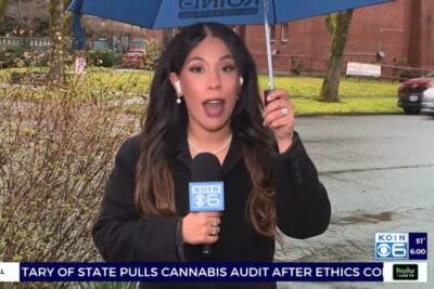 Newscaster covering the Oregon Measure 114 story.