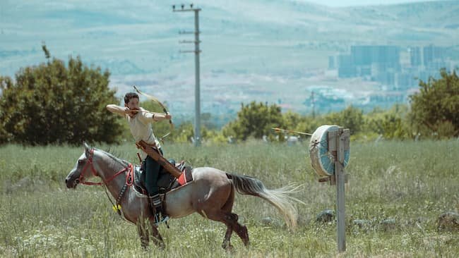 recurve archer shooting a target on horseback