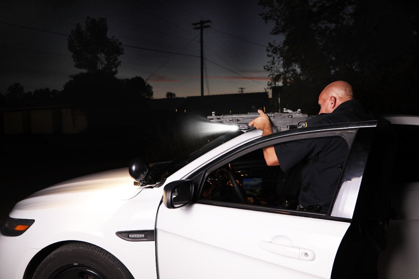 police officer using patrol car for cover