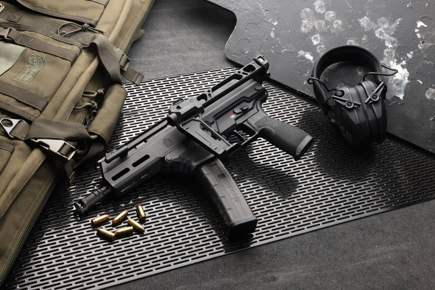 Shown here with a set of hearing protection and loaded ammunition, the Springfield Armory Kuna is tested on the shooting range.